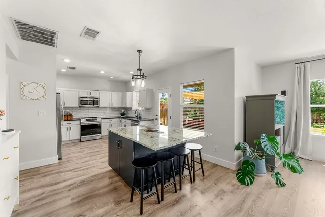 a kitchen with stainless steel appliances granite countertop a stove and a wooden floors