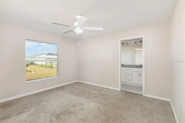 an empty room with a ceiling fan and a window