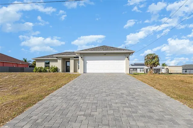 a front view of a house with a yard and garage