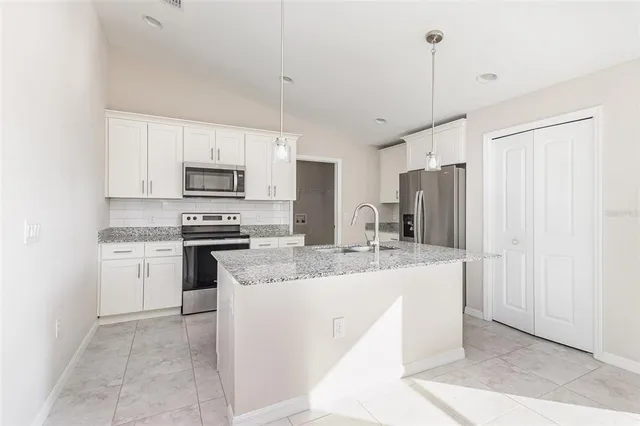 a kitchen with kitchen island a sink appliances and cabinets
