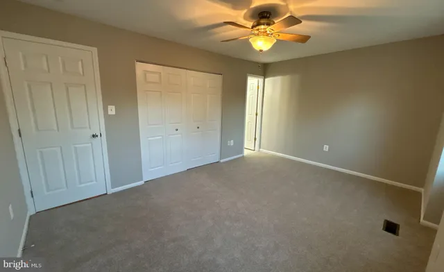 an empty room with a ceiling fan and a window