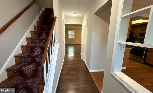a view of a hallway with wooden floor and staircase