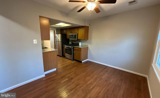 an empty room with wooden floor and chandelier