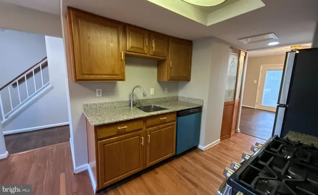 a kitchen with granite countertop a sink stove and refrigerator
