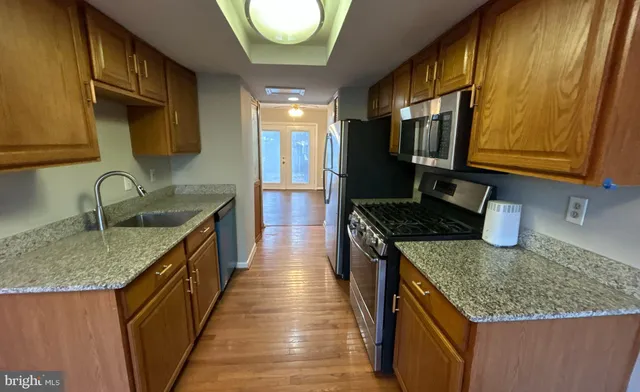 a kitchen with granite countertop sink stove and cabinets