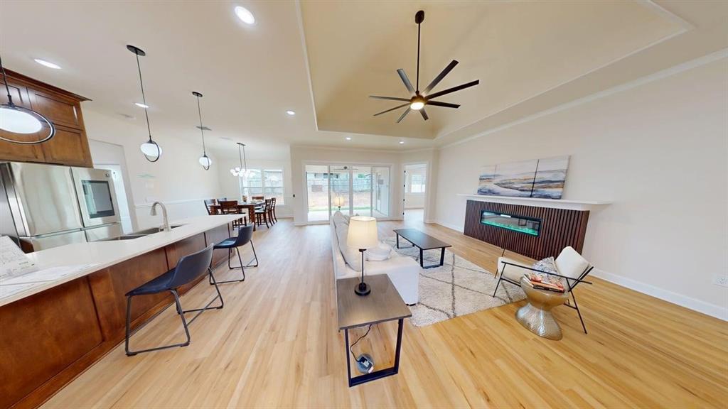 2509 Windmill Lane Longview, TX 75601 - Photo 5 of 35 Living room featuring light wood finished floors, a raised ceiling, ceiling fan, a fireplace, and recessed lighting