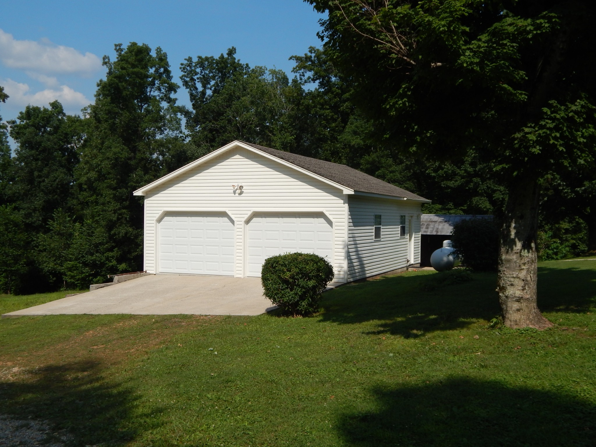 3753 Chisholm Road Iron City, TN 38463 - Photo 36 of 50 a view of a white house with a small yard and large trees