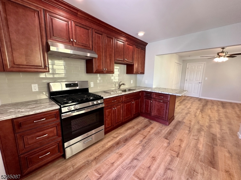a kitchen with stainless steel appliances granite countertop wooden cabinets and a stove top oven