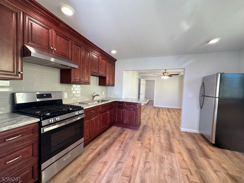 16 Colfax Street, Unit 4 Raritan, NJ 08869 - Photo 4 of 15 a kitchen with stainless steel appliances granite countertop a stove a refrigerator and a wooden cabinets