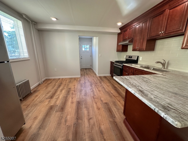 16 Colfax Street, Unit 4 Raritan, NJ 08869 - Photo 5 of 15 a kitchen with granite countertop a sink stove and cabinets