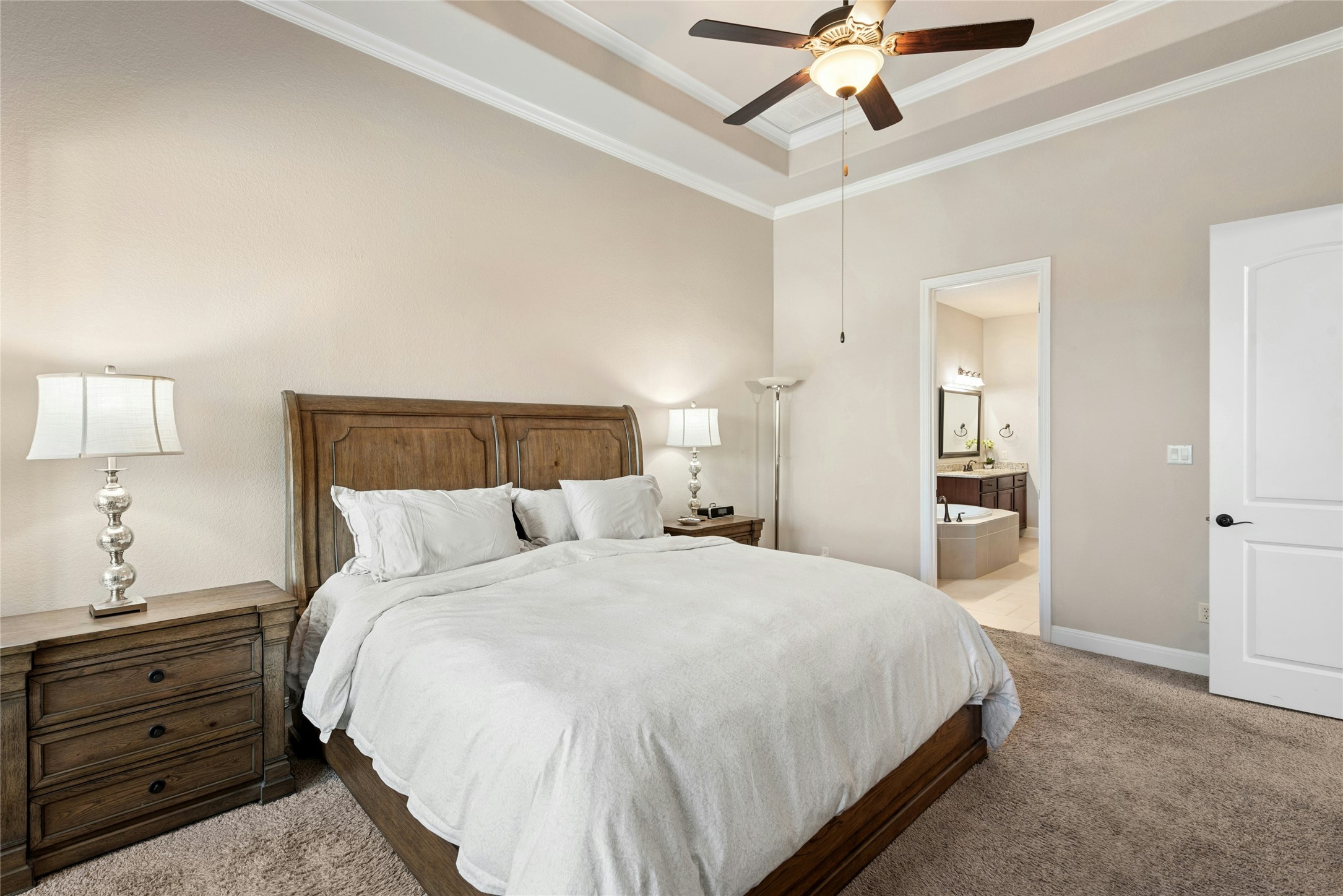 116 Evolutions Path Lakeway, TX 78738 - Photo 17 of 34 Bedroom featuring a tray ceiling, ornamental molding, carpet flooring, ceiling fan, and connected bathroom