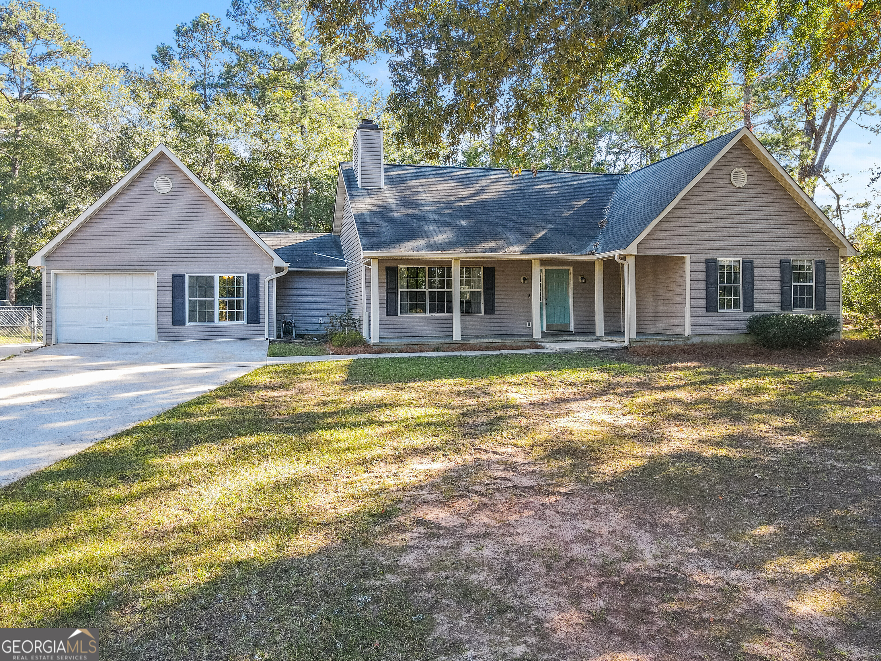 a view of a house with a yard and large tree