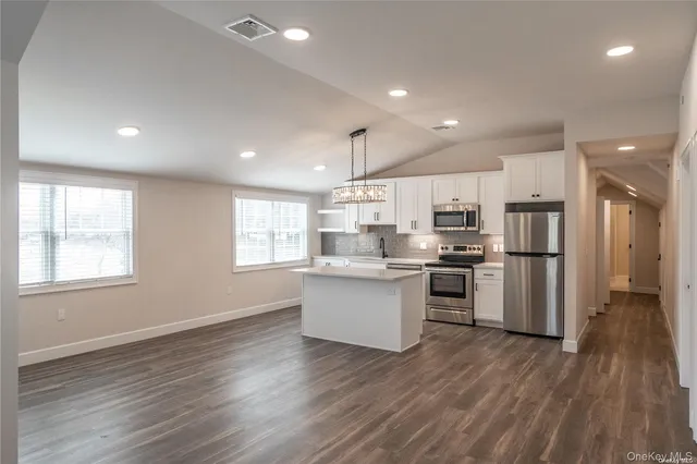 a kitchen with a refrigerator and wooden floor