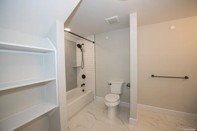 a bathroom with a granite countertop sink mirror and toilet