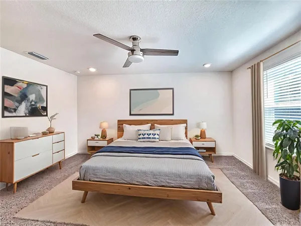 a spacious bedroom with a bed and window