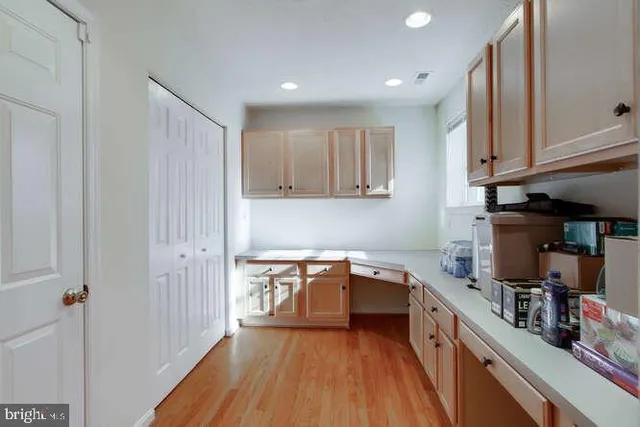 a kitchen with a sink and wooden floor