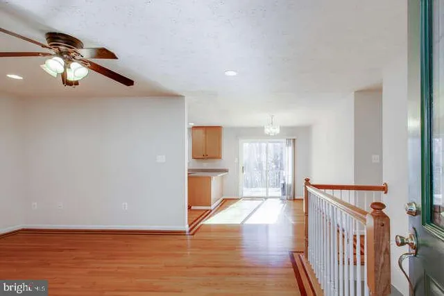 a view of a room with wooden floor electronic appliances and a window