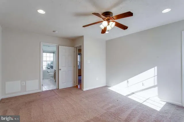 an empty room with closet and a ceiling fan