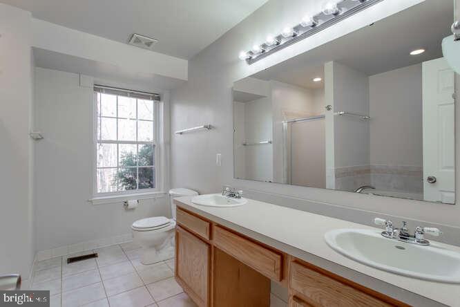 8610 Turkey Hill Road White Plains, MD 20695 - Photo 20 of 47 a bathroom with a double vanity sink a toilet and a mirror