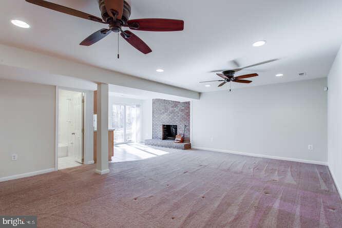 8610 Turkey Hill Road White Plains, MD 20695 - Photo 36 of 47 a view of an empty room with a fireplace and a ceiling fan