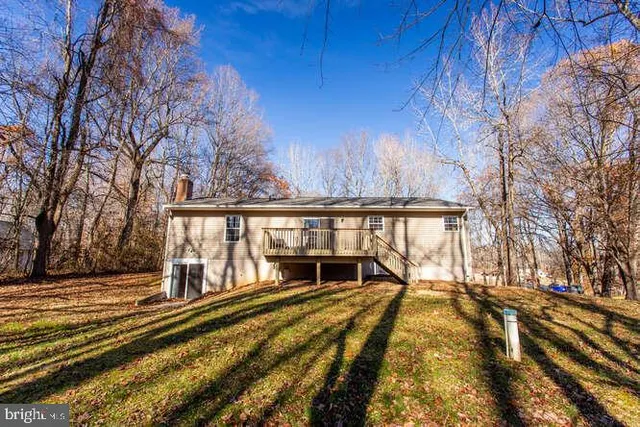 a view of a house with backyard and trees