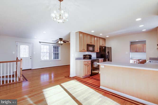 8610 Turkey Hill Road White Plains, MD 20695 - Photo 6 of 47 a kitchen with stainless steel appliances granite countertop a refrigerator a stove top oven a sink dishwasher and white cabinets with wooden floor