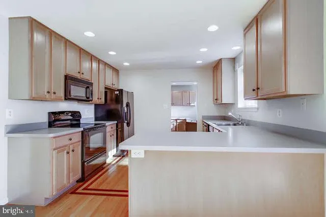 a kitchen with stainless steel appliances granite countertop a sink refrigerator and microwave