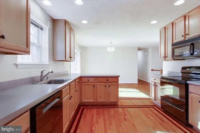 a kitchen with stainless steel appliances granite countertop a sink stove and cabinets