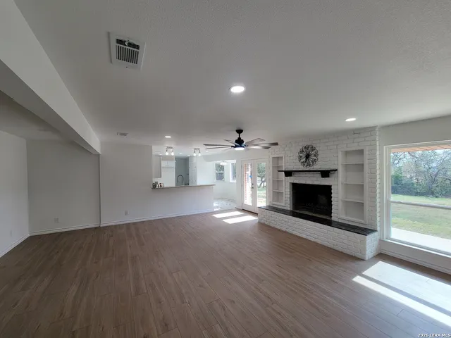 a view of empty room with wooden floor and fireplace