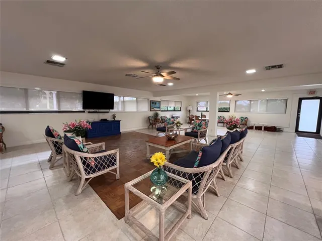 a living room with furniture a flat screen tv and a kitchen view