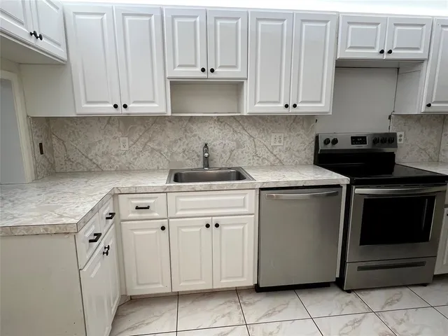 a kitchen with cabinets appliances and a sink