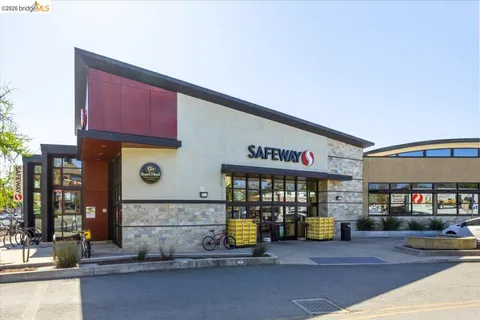 a front view of multi story building with retail shops