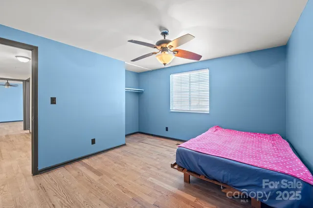 a bedroom with a bed a chandelier and a window