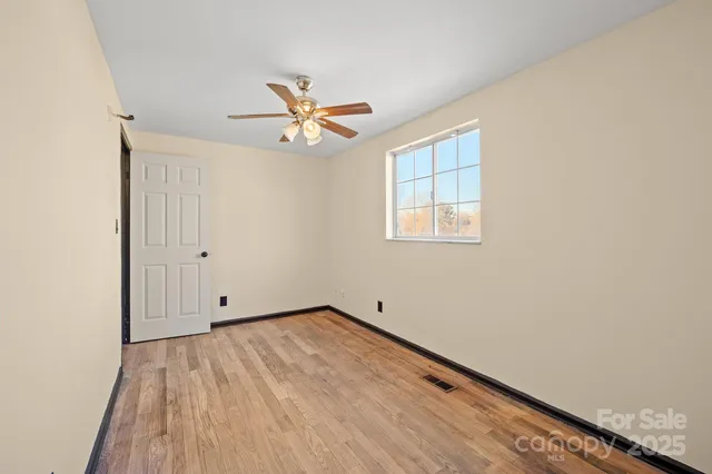 a view of room with wooden floor and fan