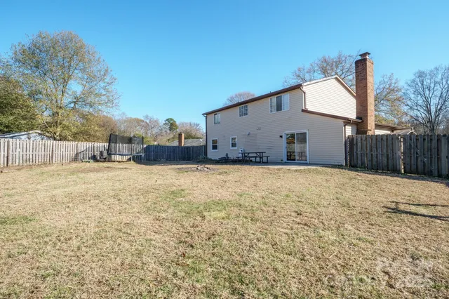 a view of a yard with wooden fence