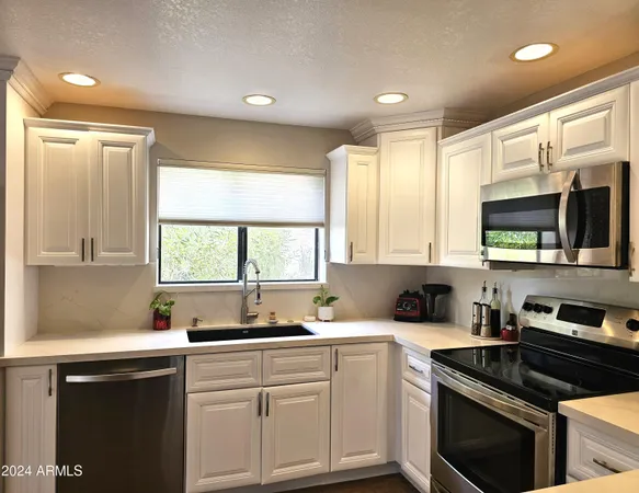 a kitchen with a sink stove top oven and cabinets