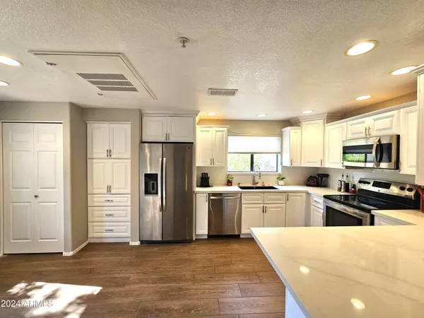 a kitchen with stainless steel appliances granite countertop a refrigerator and a stove top oven