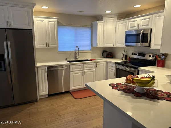 a kitchen with stainless steel appliances a sink stove refrigerator and cabinets