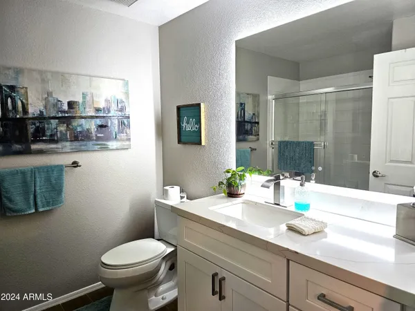 a bathroom with a granite countertop toilet sink and mirror