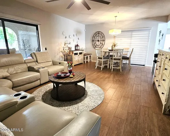 a living room with furniture a clock on wall and a large window