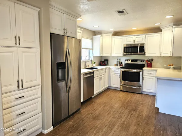 a kitchen with white cabinets and stainless steel appliances