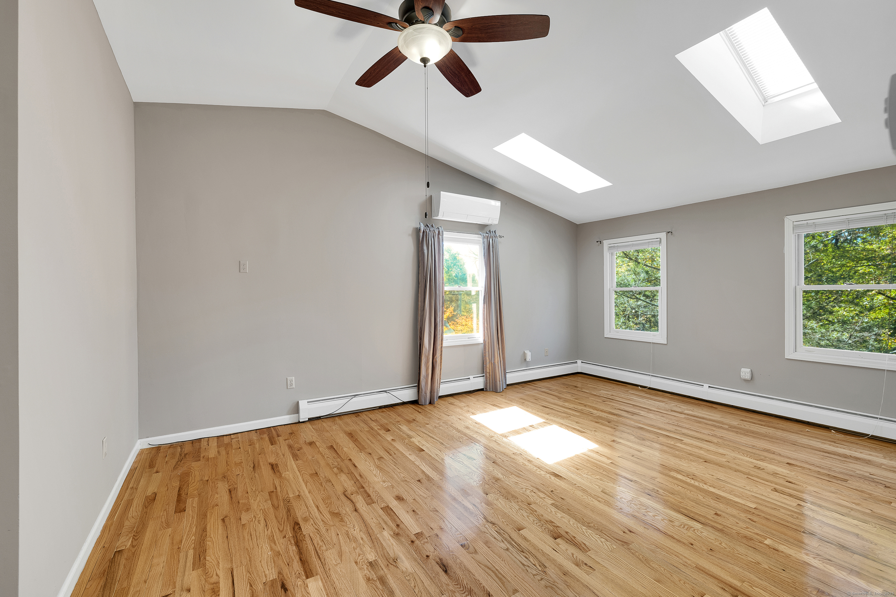 367 Sachem Road Southbury, CT 06488 - Photo 16 of 34 an empty room with wooden floor chandelier fan and windows