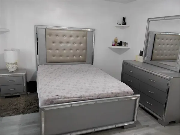 a room with a bed and dresser
