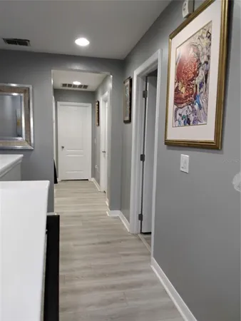 a view of a hallway with wooden floor