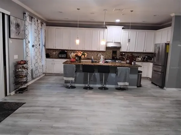 a kitchen with stainless steel appliances a refrigerator and a stove top oven