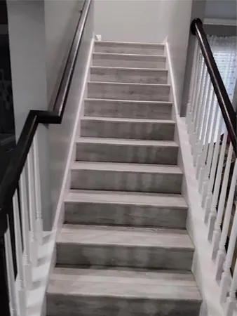 a view of staircase with white walls and railing