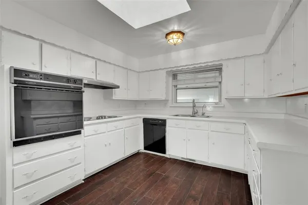 a kitchen with granite countertop cabinets stainless steel appliances and wooden floor