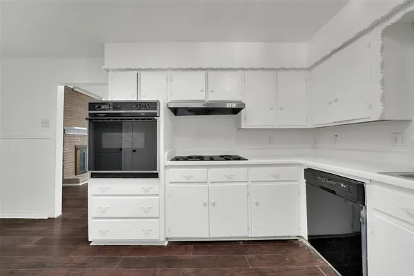 a kitchen with white cabinets and appliances