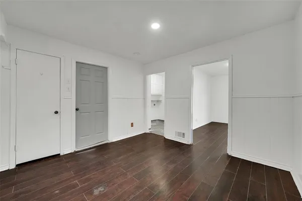 a view of an empty room with wooden floor