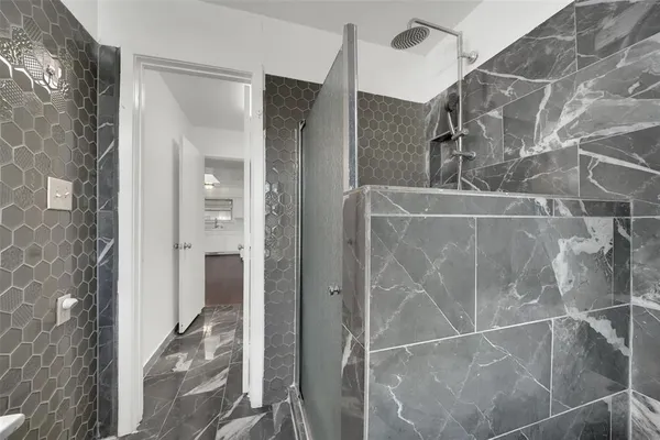 a bathroom with a glass shower door and mirror